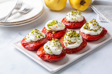 Traditional Turkish style quince dessert. The quince is cooked until soft, sherbet is poured on it, and served with cream and walnuts. It is one of the most popular Turkish desserts.(Ayva Tatlisi)