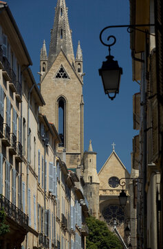 Line of apartments contrasts with an old church that dominates skyline in Aix-En-Provence, France.
