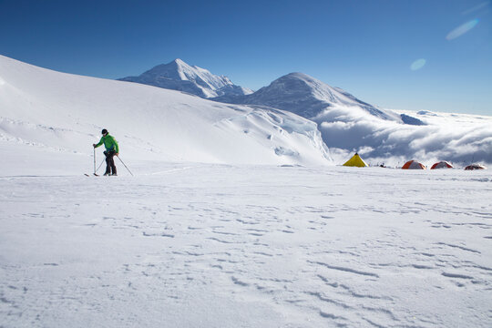 A ski mountaineer on the Kahiltna glacier of Denali National Park in Alaska, with mount Foraker and Kahiltna Dome in the background.