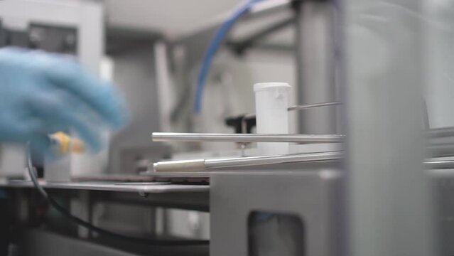 m&aacute;quina industrial para la selecci&oacute;n de productos farmac&eacute;uticos en envases de color blanco y pl&aacute;stico sobre cinta corredera para empresa de la industria farmac&eacute;utica.