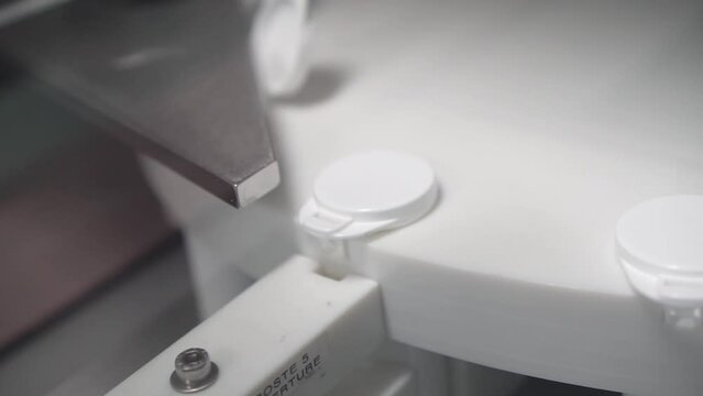 m&aacute;quina industrial de empresa farmac&eacute;utica para apertura de envases para medicamentos de color blanco y de pl&aacute;stico.