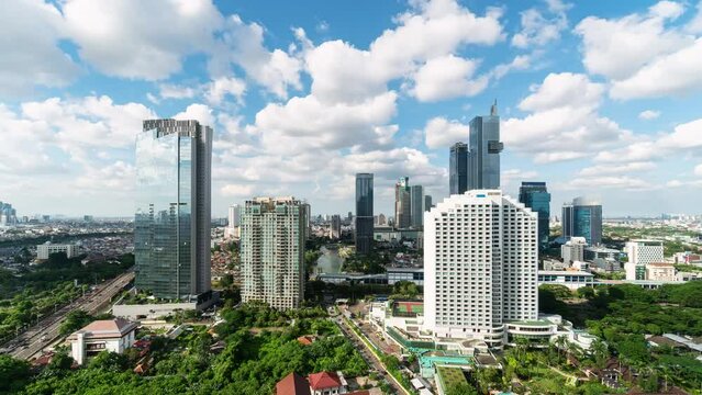 Jakarta, Indonesia: Time lapse of clouds moving fast above the Jakarta business modern skyline with skyscrapers and condominium towers in Indonesia capital city. 