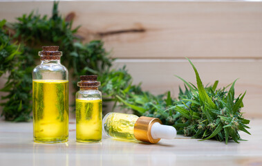 Oil cannabidiol CBD with bud marijuana on wood background