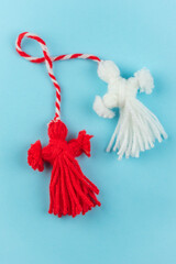 Traditional Martisor - symbol of holiday 1 March, Martenitsa, Baba Marta, beginning of spring and seasons changing in Romania, Bulgaria, Moldova. Greeting and post card for holidays. Blue background.