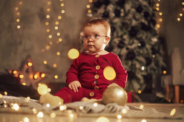 In glasses. Cute little baby is at home. New year decorations. Conception of holidays