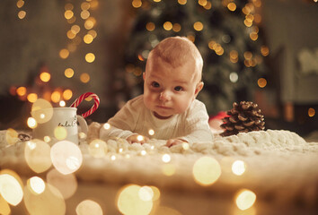 Front view. Beautiful portrait. Cute little baby is at home. New year decorations. Conception of holidays