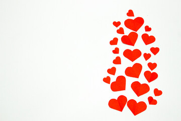 Valentine’s day background. Red hearts isolated on white. Love-shaped paper-cut decorations for International Women’s Day or Mother’s Day. Flat lay. Left copy space