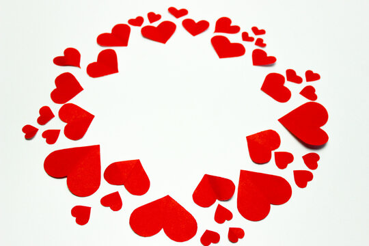 Valentine&rsquo;s day background. Red hearts in a circle shape isolated on white. Love-shaped paper-cut decorations for International Women&rsquo;s Day or Mother&rsquo;s Day. Flat lay. Copy space