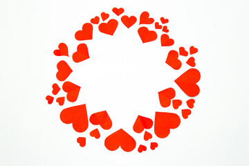 Valentine’s day background. Red hearts in a circle shape isolated on white. Love-shaped paper-cut decorations for International Women’s Day or Mother’s Day. Flat lay. Copy space