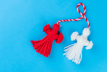 Traditional Martisor - symbol of holiday 1 March, Martenitsa, Baba Marta, beginning of spring and seasons changing in Romania, Bulgaria, Moldova. Greeting and post card for holidays. Blue background.