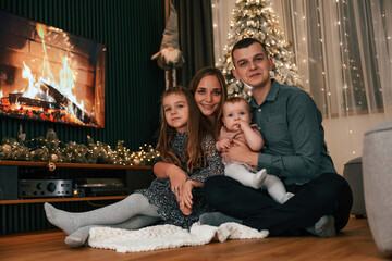 Fototapeta na wymiar Happy family is sitting together at home. Celebrating New Year