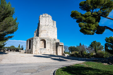 Nimes, Occitanie, France - The historical Magne tower and gardens against a blue sky