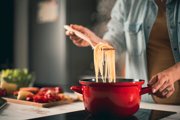 Beautiful pregnant woman preparing delicious food. Smiling woman preparing delicious food.