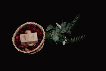 Cesta de mimbre con flores secas aromáticas dentro y dos cubos de madera con el número 14 puesto...