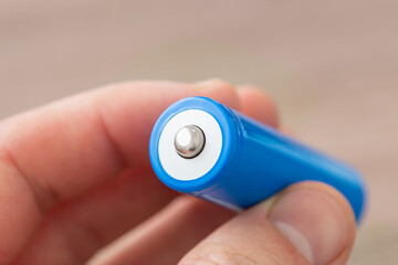 Man holding new 18650 type battery in hands. Using high capacity li-ion battery in electronics