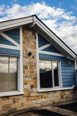 blue wooden house facade with white and stone details