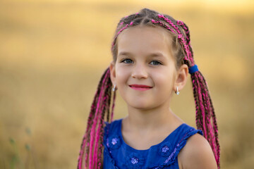 A six-year-old girl with dreadlocks in the field.