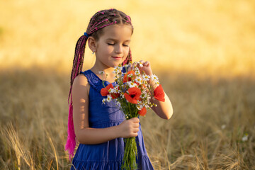A six-year-old girl in a wheat field with a bouquet of flowers.