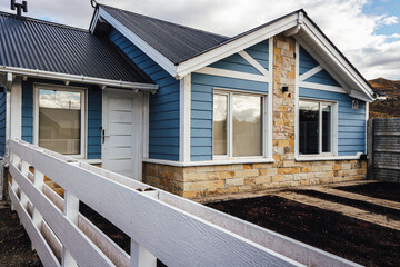 blue wooden house facade with white and stone details