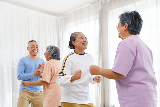 Active Asian Senior Group Mix With Man And Woman Exercise By Dancing Together With Relaxing, Smiling And Laughing. Indoor Activity For Mature Seniors And Retirement People. Focus On Senior Woman.