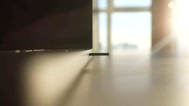 Extreme close up of unrecognizable male hands removing speedy SD card into card reader laptop slot at table on background of window and bright sun light. Shooting in slow motion.