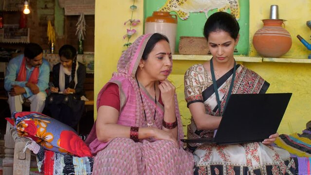 An educated government office - welfare schemes on laptops  computer education  creating awareness  Indian village home. A middle-aged village housewife learning computers - modern village couple  ...