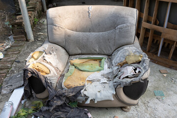 a badly damaged sofa in the outdoor at horizontal composition