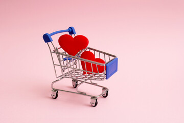 basket with heart, shopping trolley on pink background