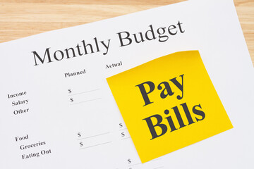 Reminder to pay bills with your monthly budget with a sticky note with