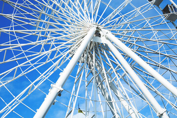 Fragment of a ferris wheel against the blue sky