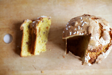 Traditional italian Panettone, typical Christmas cake, on a chopping board with two slices ready to be tasted.