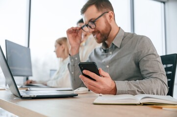 Side view of man that is sitting. Successful team are working together in the office. Conception of business