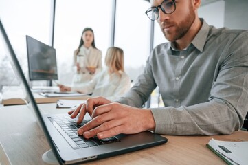 Obraz premium Close up view, using laptop. Successful team are working together in the office. Conception of business