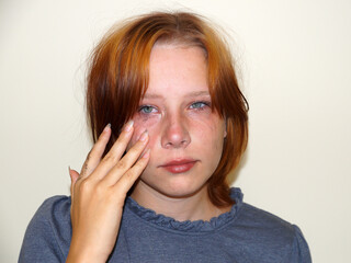 portrait of a sad red-haired teenage girl with a tear-stained face