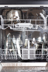 Clean plates after washer in the opened dishwasher.