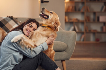 Conception of care. Woman is with golden retriever dog at home