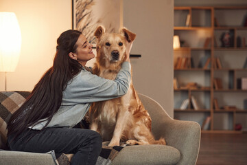 Positive emotions. Playing together. Woman is with golden retriever dog at home