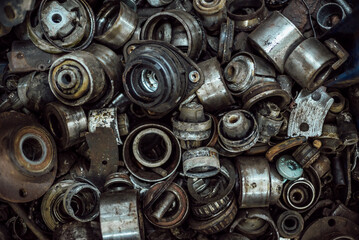 a large number of old rusty and oil-stained car parts