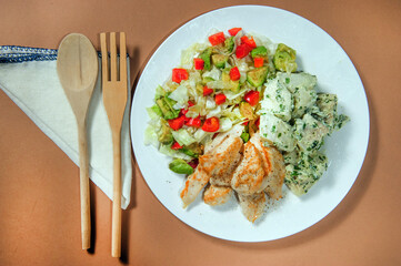 Breaded chicken breast with potato salad.Studio shot.