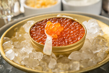 Orange Keta Lachs Kaviar in Dose auf Eis in Glas Schale mit Perlmutt Löffel, Sekt Champagner,...