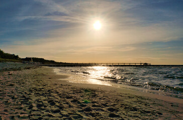 Groynes jut into the sea at sunset. The sun shines on the Baltic Sea. Landscape