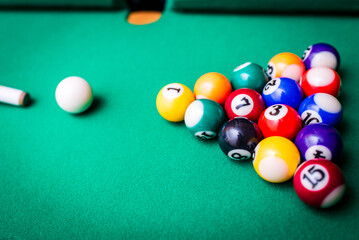 Billiard balls on the green table with billiard cue, Snooker,Pool game.Cue aim billiard snooker pyramid on green table.Top view.