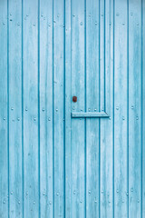 Texture of an old wooden door painted blue somewhere in Greece