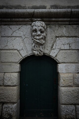 Face statue above stone door entrance