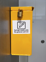 Needle drop box situated in a ladies public toilet - for the safe disposal of used needles to prevent the spread of disease.