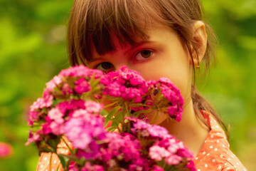 Fototapeta premium Beautiful charming cheerful young girl with colorful wildflowers.