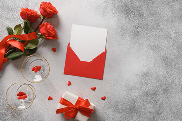Valentine's day greeting card with red roses, romantic gift, blank for love letter on gray background. View from above. Copy space.