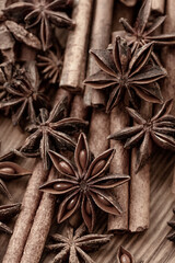 Background with cinnamon sticks, anise stars, coffee beans and nuts. Spicy trendy background. Close-up of various spices on wooden table top view