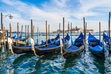 Gondolas floating by the shoreline of San Marco Square in front of the Island of San Giorgio Maggiore in Venice, Italy