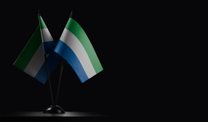 Small national flags of the Sierra Leone on a black background